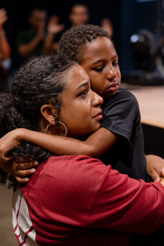 Mulher abraça um menino durante um encontro na igreja.