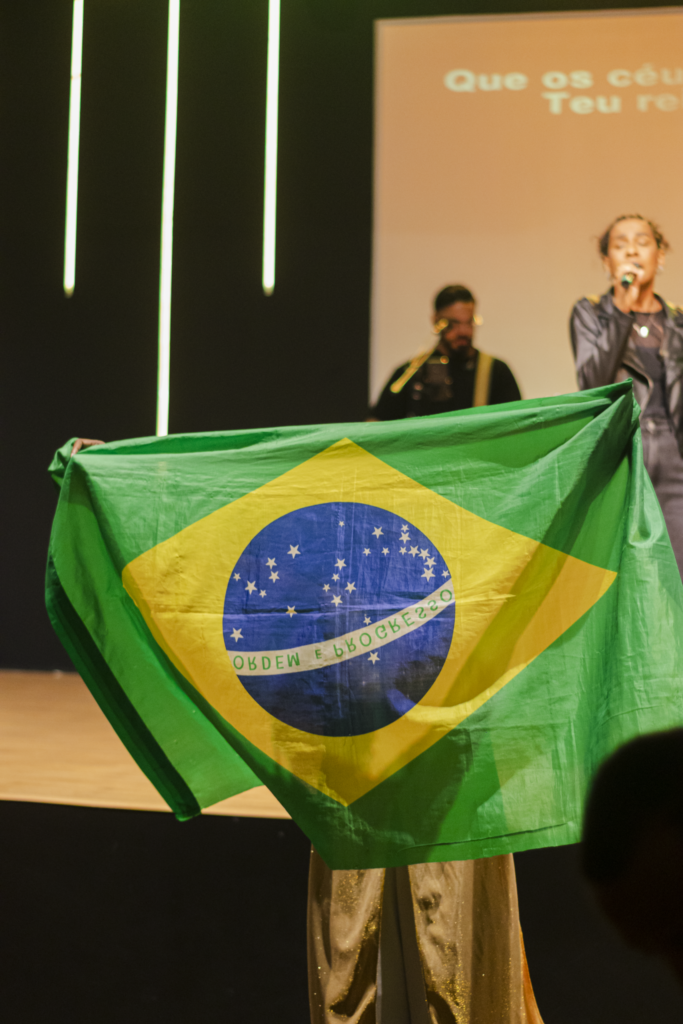 Participante com as mãos levantadas durante a pregação em um culto na MEVAM Campinho