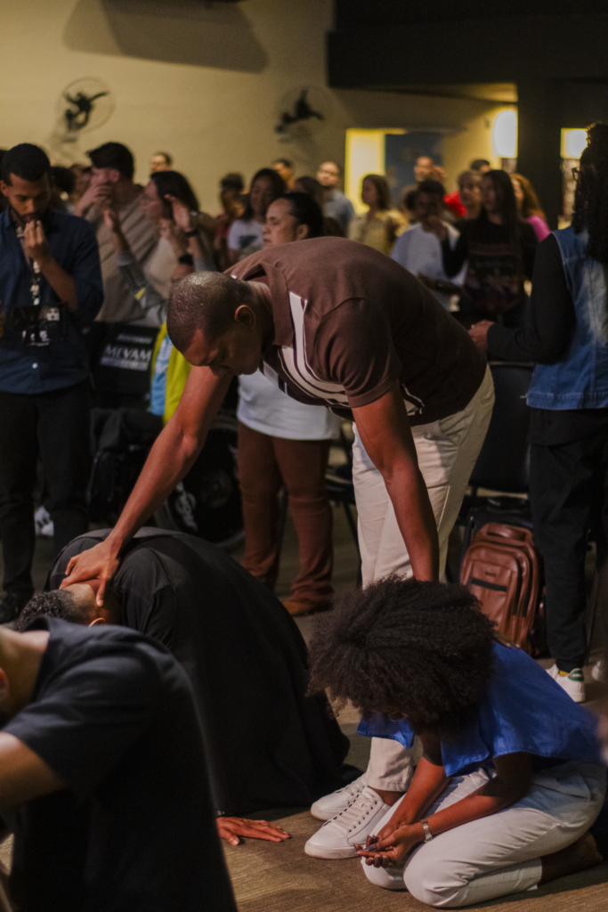 Participantes recebem apoio e oração durante um encontro na igreja.